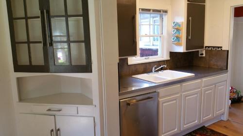 una cocina con armarios blancos y fregadero en The Red Smarthouse King ❤ of Downtown W/D WiFi, en Klamath Falls