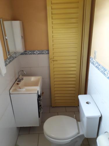 ein Badezimmer mit einem weißen WC und einem Waschbecken in der Unterkunft Suítes Dona Ilda in Pirenópolis