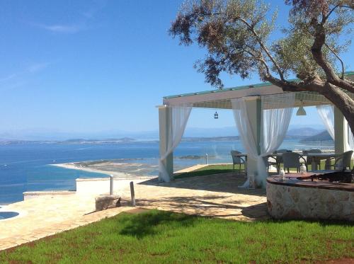 a wedding gazebo with a view of the ocean at Thea Thalatta Villas in Tsoukaladhes