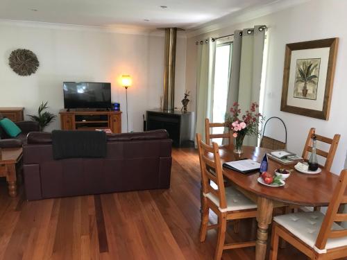 a living room with a couch and a table at Ghost Hill Road Retreat in Bilpin