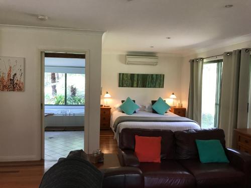 a bedroom with a bed and a couch in a room at Ghost Hill Road Retreat in Bilpin