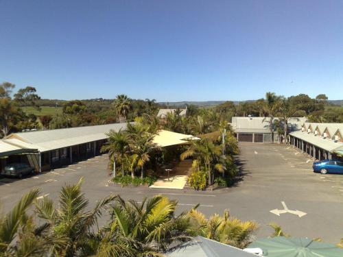 a building with a lot of palm trees and a parking lot at McLaren Vale Motel & Apartments in McLaren Vale