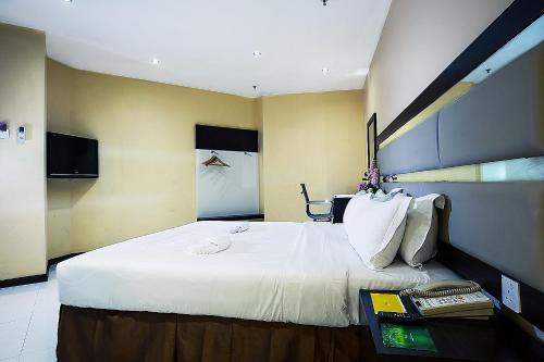 a hotel room with a large bed with white sheets at Ixora Hotel Penang in Perai