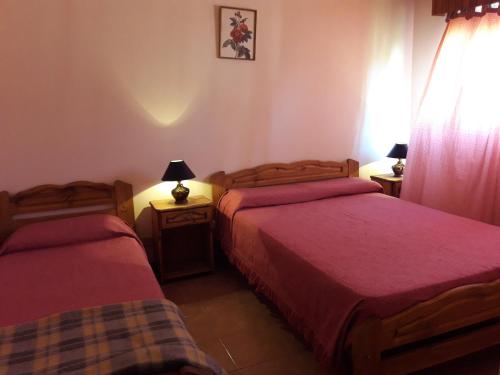una habitación de hotel con dos camas y ventana en el Hotel Molise de Villa Gesell