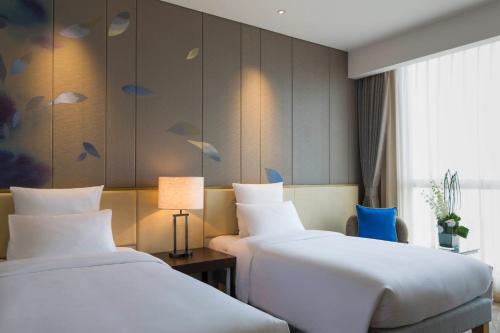 מיטה או מיטות בחדר ב-Pullman Nanchang Sunac