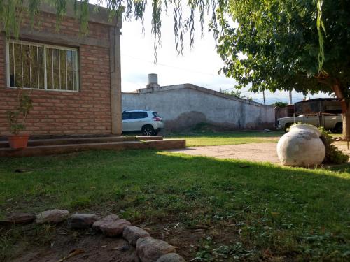 a sheep sitting in a yard next to a house at Casa Las Moras in La Rioja