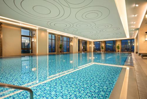 a swimming pool with a tile ceiling in a hotel at Shangri-La Jinan in Jinan