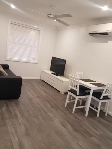 a living room with a table and a tv at Edwin Place Apartment in Glenwood