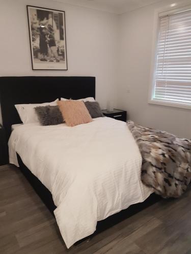 a bedroom with a white bed with a black headboard at Edwin Place Apartment in Glenwood