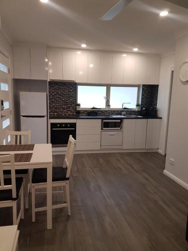 a kitchen with white cabinets and a table with chairs at Edwin Place Apartment in Glenwood