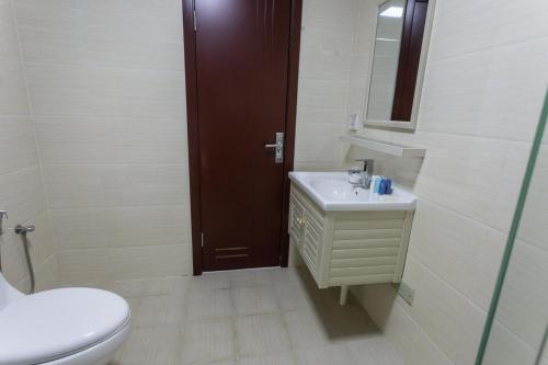 a bathroom with a toilet and a sink and a mirror at 钻石名邸 Diamond One Hotel and Serviced Apartment in Phnom Penh