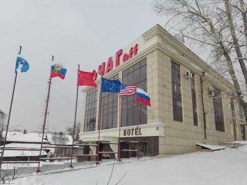 un hotel con tres banderas delante en Hotel Ochagof en Irkutsk