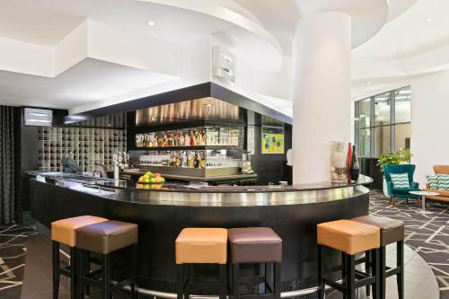 a bar in a hotel lobby with stools at Mantra Parramatta in Sydney
