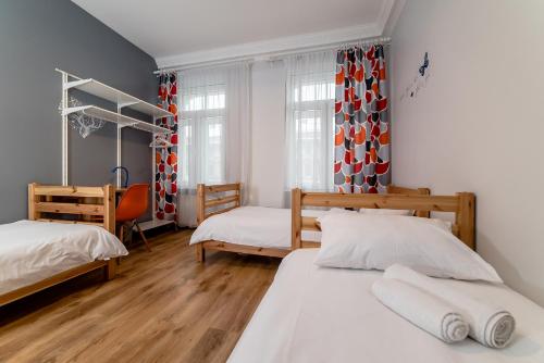 a bedroom with two beds and a desk in it at Orange Cat Rooms in Riga