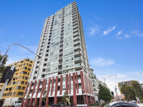 a tall building on a street in a city at As the Sun Sets - Modern and Spacious 2BR Zetland Apartment Facing the Setting Sun in Sydney