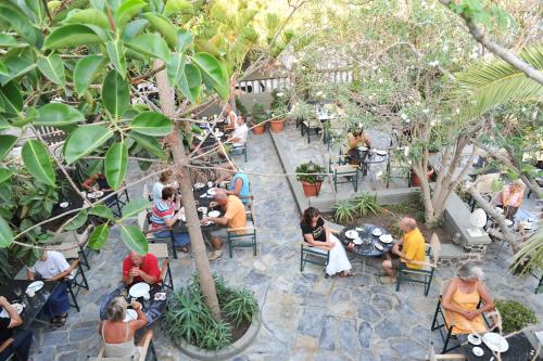 a group of people sitting at tables in a restaurant at Zephyros Hotel in Kamari