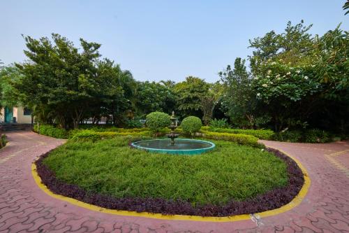 a garden with a fountain in the middle of a park at Aacorn Hideaway Resort & Spa in Rāmnagar