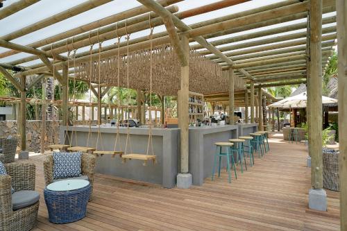 a restaurant with a bar with chairs and tables at Coin de Mire Attitude in Cap Malheureux