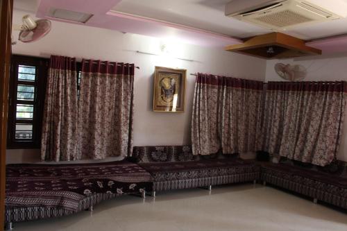 a living room with curtains and a couch at Classic Dineout in Gandhinagar