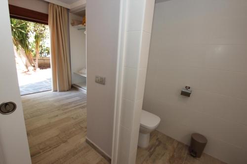 Un baño blanco con inodoro y puerta. en Apartments FIBAN Finca SanJuan Batista, en Guía de Isora