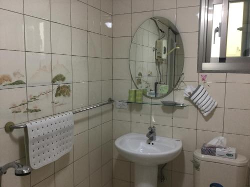 a bathroom with a sink and a mirror at Fu Courtyard Homestay in Shui-shang