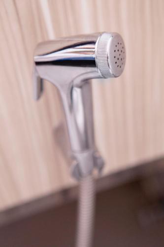 a blow dryer sticking out of a chrome faucet at The Charter House in Manila