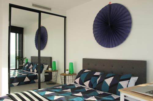 a bedroom with a bed and a purple umbrella on the wall at Spectacular Views of CBD by FV with Free Car Park in Brisbane
