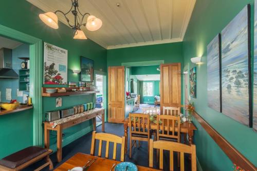 a dining room with green walls and a table and chairs at The Great Ponsonby Arthotel in Auckland
