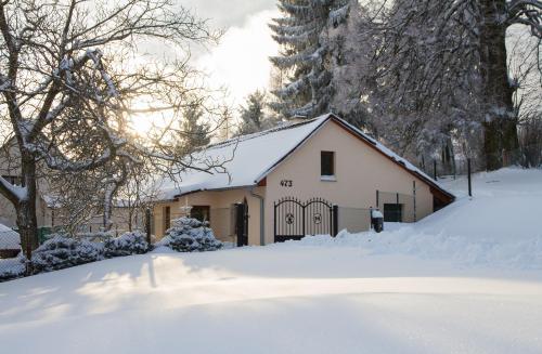 a white building with a gate in the snow at Burg nad Banskou Štiavnicou in Štiavnické Bane
