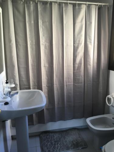 a bathroom with a sink and a shower curtain at Apartamento Aguadulce Plaza Caribe in Aguadulce