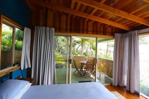 a bedroom with a bed and a balcony at Benji's By The Sea in Scotts Head