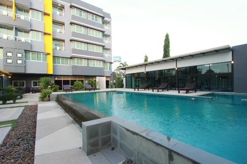 uma piscina em frente a um edifício em The Park 304 Executive Serviced Apartment em Si Maha Phot