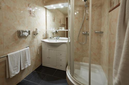 ein Bad mit einer Dusche und einem Waschbecken in der Unterkunft Panoramahotel Berghof in Baiersbronn