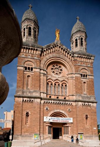 a large brick building with two towers on top at Hotel Le 21 in Saint-Raphaël