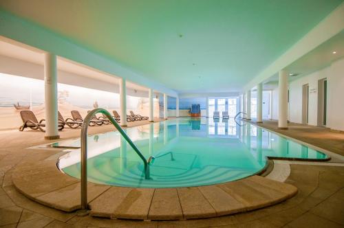 a large swimming pool in a building at Promenadenhotel Admiral in Bansin