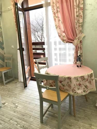 エストサドクにあるВ окружении горのテーブルと椅子、ピンクのテーブル、窓