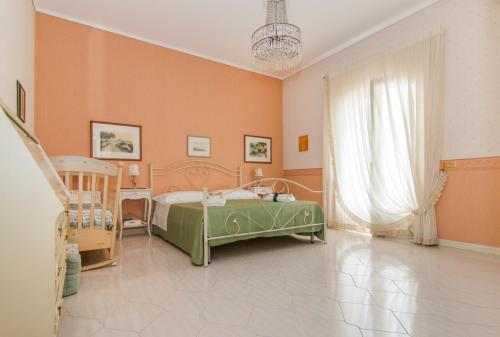 a bedroom with a green bed and orange walls at Vivi La Contea in Modica