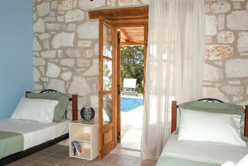 ヴァシリコスにあるAloniのベッドルーム1室(ベッド2台付)、プールへのドアが備わります。