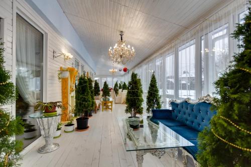 una sala de estar llena de árboles de Navidad y un sofá azul en Royal Relaxing Spa, en Vnukovo