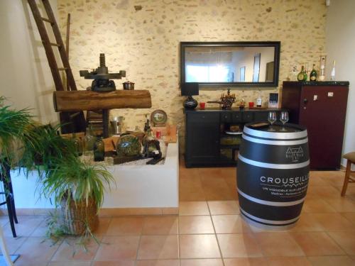 a room with a barrel on the floor and a kitchen at Le Pressoir B&B in Aydie