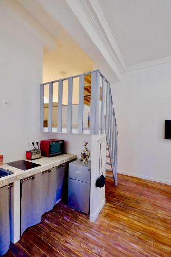 une cuisine avec un comptoir et un escalier dans l'établissement Appartement Bordeaux Victoire, à Bordeaux