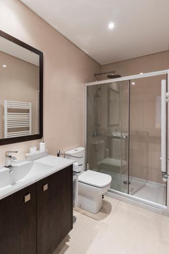 a bathroom with a toilet and a sink and a shower at Flea Market Alfama House (Patio/Pool/AC/Garage) in Lisbon