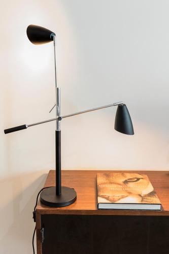 a lamp sitting on top of a desk with a book at Flea Market Alfama House (Patio/Pool/AC/Garage) in Lisbon