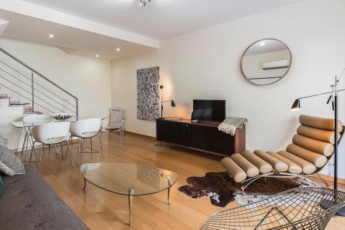 a living room with a couch and a table and a mirror at Flea Market Alfama House (Patio/Pool/AC/Garage) in Lisbon