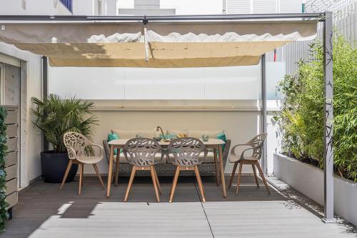 a table and chairs under an umbrella on a patio at Flea Market Alfama House (Patio/Pool/AC/Garage) in Lisbon