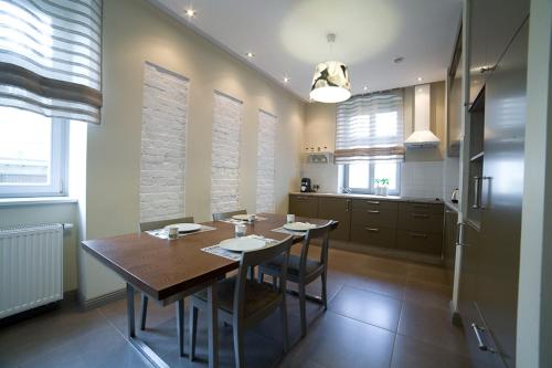 a kitchen with a wooden table and a dining room at Avalis Apartamenty in Poznań