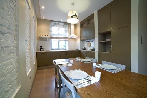 una cucina con un grande tavolo di legno con sedie di Avalis Apartamenty a Poznań