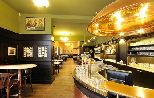 a restaurant with a bar with tables and chairs at Rezidence Mandragora in Pardubice