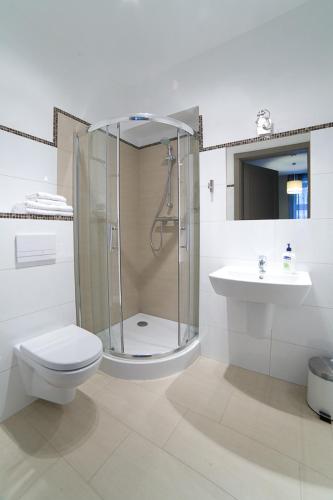 un bagno con doccia, WC e lavandino di Avalis Apartamenty a Poznań