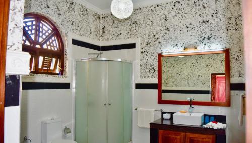 bagno con cabina verde e specchio di Rico Shadow Guest House & Restaurant a Wayikkal